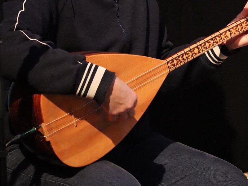 Person spielt Saiteninstrument