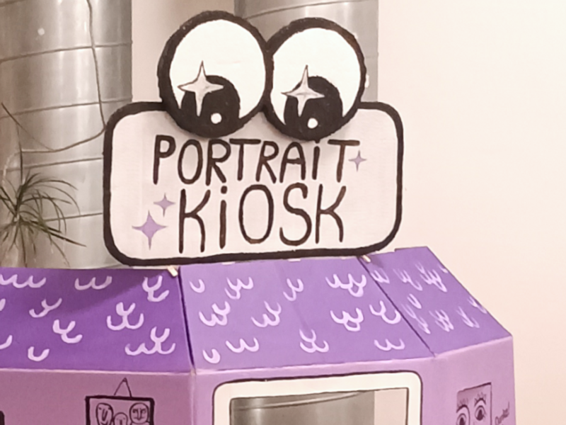 Der Portrait Kiosk ist im Kölibri aufgebaut. Über einem Durchguck sind zwei große Kulleraugen.